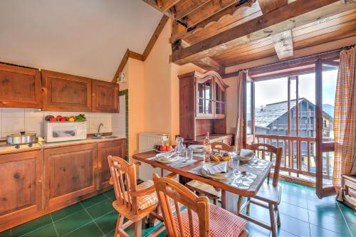 una cucina e una sala da pranzo con tavolo e sedie di Grange Hike & Ski Sestriere Apartments - Happy.Rentals a Sestriere