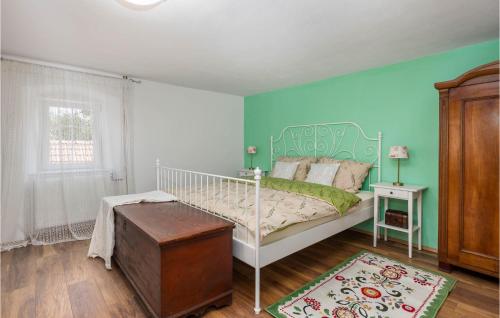 a bedroom with a white bed and a green wall at Nice Home In Otocac With Sauna in Otočac