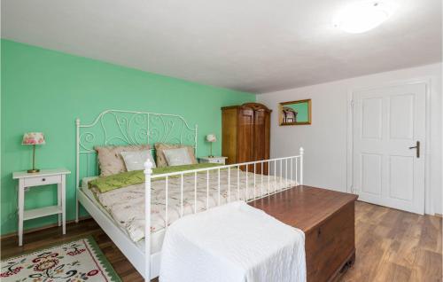 a bedroom with a white bed and a blue wall at Nice Home In Otocac With Sauna in Otočac