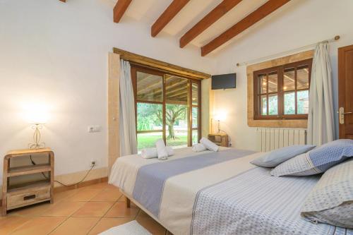 a bedroom with two beds and a window at S'Era Nova in Algaida