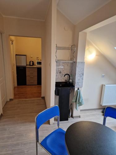 a room with a table and chairs and a kitchen at Centrum Noclegowe Apartament 6 in Bydgoszcz