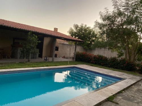 a swimming pool in front of a house at Chalés toca do guaxinim in Itarema