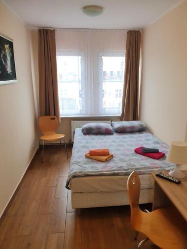 een slaapkamer met een bed, een bureau en een raam bij Centrum Noclegowe Apartament 6 in Bydgoszcz