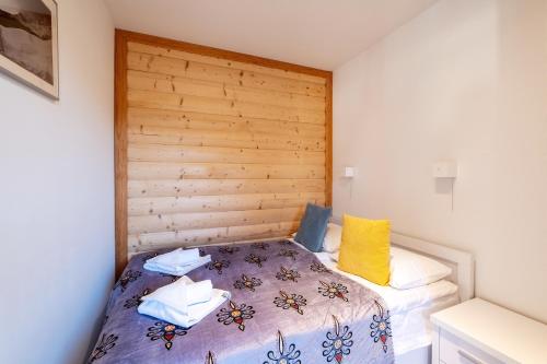 - une chambre avec un lit et une tête de lit en bois dans l'établissement Szymaszkowa 3 by Homeprime, à Zakopane