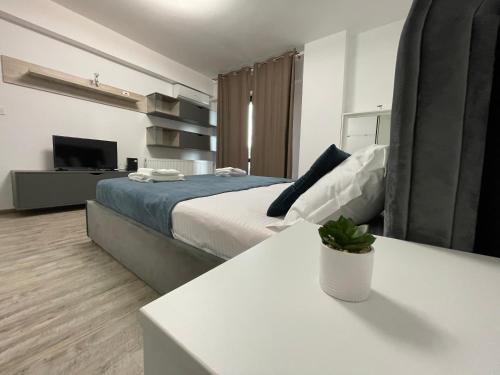 een slaapkamer met een bed en een tafel en een televisie bij Iulius Mall River Tower in Iaşi
