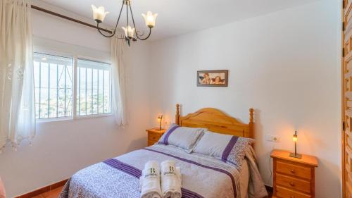Un dormitorio con una cama con dos zapatos. en Finca Los Pinos Cómpeta by Ruralidays, en Cómpeta