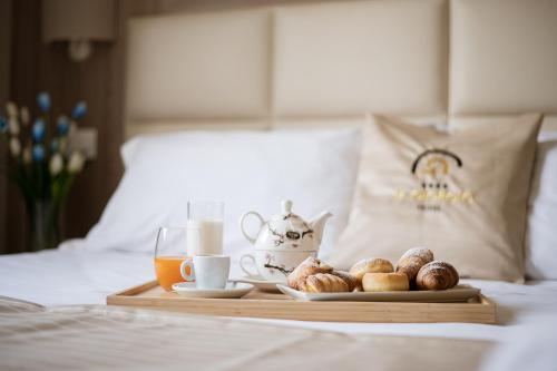a tray with a breakfast of coffee and pastries on a bed at Hotel St. Giorgio in Castel San Giorgio