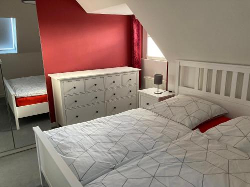 a bedroom with a white bed and a red wall at Villa Am Honigbach in Coesfeld
