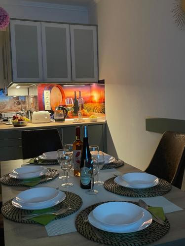 a table with plates and glasses and a bottle of wine at Corner Apartment in Budapest