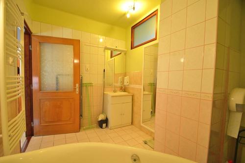 a bathroom with a tub and a toilet and a sink at Nora Ház Hajdúszoboszló in Hajdúszoboszló