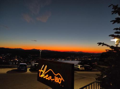 a sign in a parking lot with the sunset in the background at 180 mountain lodge in Ioannina