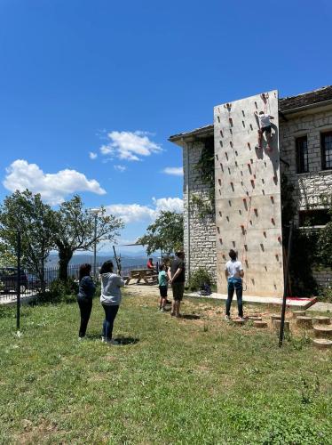 a group of people standing next to a climbing wall at 180 mountain lodge in Ioannina
