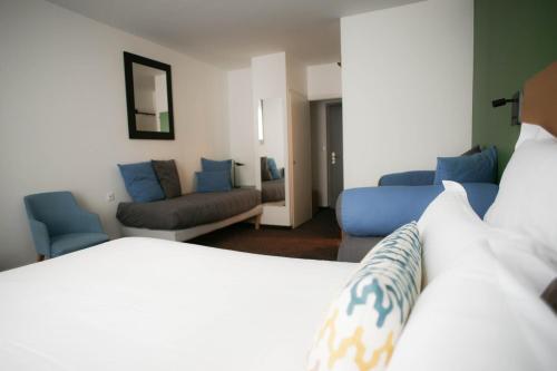 ein Hotelzimmer mit einem Bett und einem Wohnzimmer in der Unterkunft Logis Hôtel de l'Europe in Poitiers