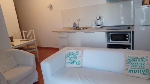 プエルト・デ・モガンにあるLa Caytispaのリビングルーム(白いソファ付)、キッチンが備わります。
