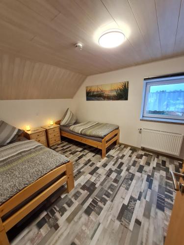 a bedroom with two beds and a window at AMW Ferienwohnungen in Legau