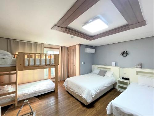 a bedroom with two bunk beds and a skylight at HY Choi Hostel in Seogwipo