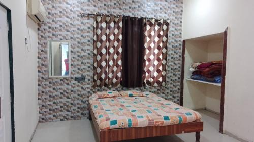 a small bedroom with a bed and a mirror at Tendulkar Beach Resort in Diveagar