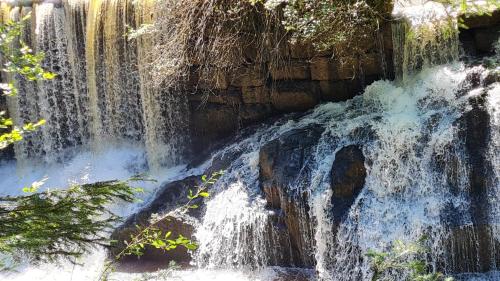 a waterfall in front of a stone wall at AMW Ferienwohnungen in Legau