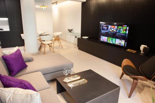 Una televisión o centro de entretenimiento en Raam Luxury Suites
