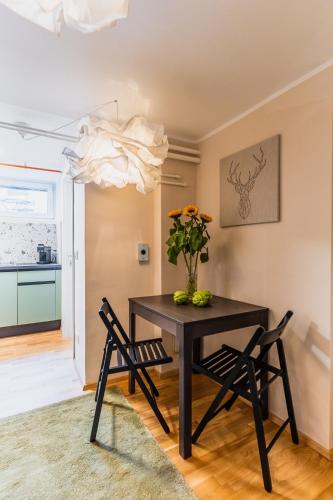 a dining room table with two chairs and a vase of flowers at Vila Valentina in Ljubljana