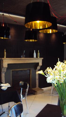 ein Esszimmer mit Kamin und goldenen Lichtern in der Unterkunft Maison Marie Barrault in Les Herbiers