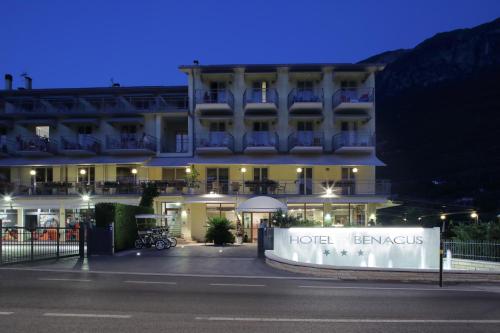a hotel with a sign in front of it at night at Eco Hotel Benacus in Malcesine