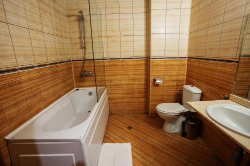 a bathroom with a tub and a toilet and a sink at Hotel BATS in Petrich