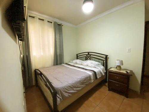 a bedroom with a bed and a dresser and a window at Amplio apartamento en Gazcue SDQ in Santo Domingo