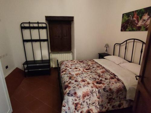 una camera da letto con un letto con copriletto floreale di Residence il giardino sul fiume Nera a Cerreto di Spoleto