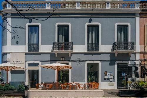 a building with tables and umbrellas in front of it at RM The Experience - Small Portuguese Hotels in Setúbal
