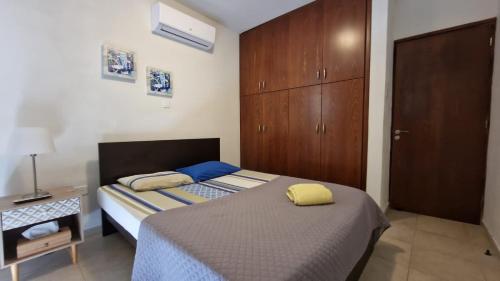 a small bedroom with a bed and a cabinet at The Stone Villa in Pissouri