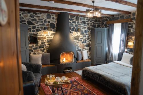 a bedroom with a fireplace in a stone wall at 4 Seasons Premium Chalet in Palaios Agios Athanasios
