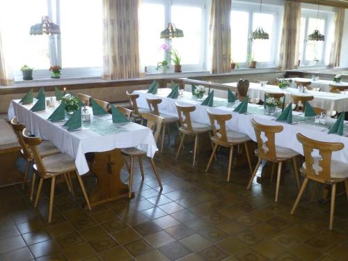 Zimmer mit Tischen, Stühlen und grünen Servietten in der Unterkunft Landgasthof "Altes Haus" in Waldmünchen