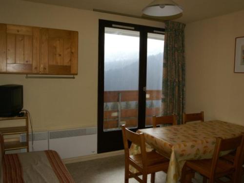 une salle à manger avec une table et une fenêtre dans l'établissement Appartement cosy proche pistes avec balcon - FR-1-557A-12, à La Ferrière
