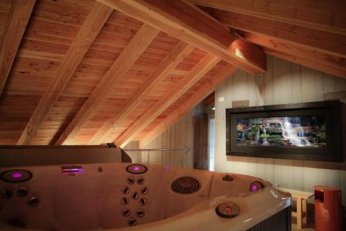 una vasca in una camera con TV a parete di Maison Farinet a Saint-Rhémy-en-bosses