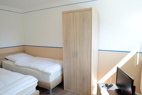 a bedroom with a bed and a cabinet with a television at La Mer Whg 03 in Wyk auf Föhr