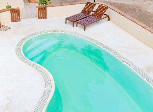 a swimming pool with a bench sitting next to it at Apartamentos El Pino - Formentera Break in Es Calo