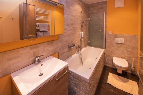 a bathroom with a sink and a tub and a toilet at Ferien beim Treiber in Bad Tatzmannsdorf