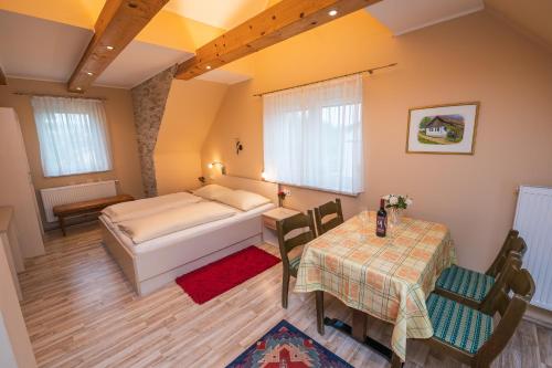 1 dormitorio con 1 cama, mesa y sillas en Ferien beim Treiber, en Bad Tatzmannsdorf