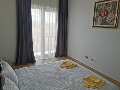 a bedroom with a bed with two yellow towels on it at Apartament incantator Iasi Copou in Iaşi