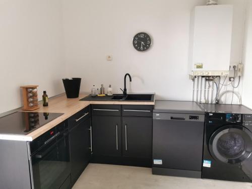 a kitchen with a sink and a washing machine at Chambre privée chez habitant à 2 pas de la gare in Blois