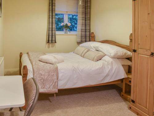 a bedroom with a bed with white sheets and a window at South Wing Coldharbour Park Farm in Rake