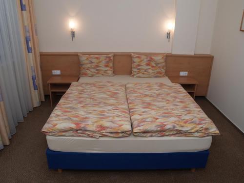 ein großes Bett in einem Zimmer mit 2 Tischen in der Unterkunft Hotel Magnet in Stryi