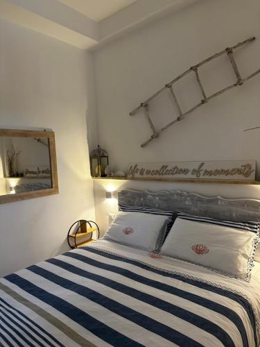 a bedroom with a bed with a blue and white striped blanket at White House in Torre Canne