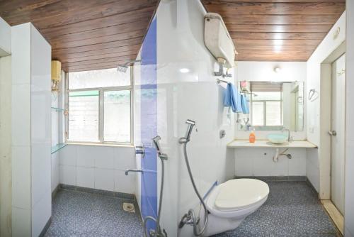 a bathroom with a toilet and a shower with a surfboard at SWARAGAN HOLIDAYS VILLA 4 BHK AC LUXURY Room private pool in Lonavala