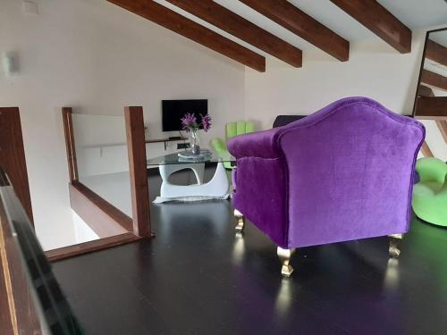 sala de estar con sofá púrpura y mesa en La Casita de Eva, en Colunga