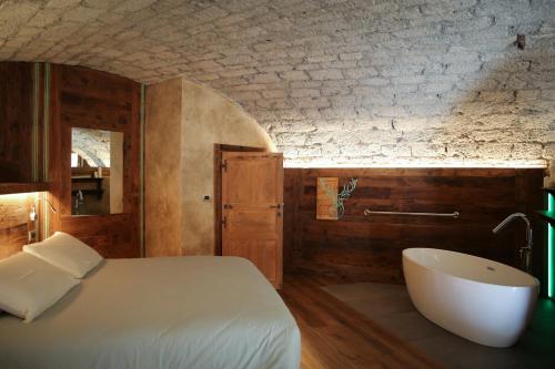 Schlafzimmer mit einem Bett und einer Badewanne in der Unterkunft Maison Farinet in Saint-Rhémy-en-Bosses
