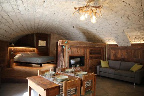 ein Wohnzimmer mit einem Tisch und einem Bett in der Unterkunft Maison Farinet in Saint-Rhémy-en-Bosses