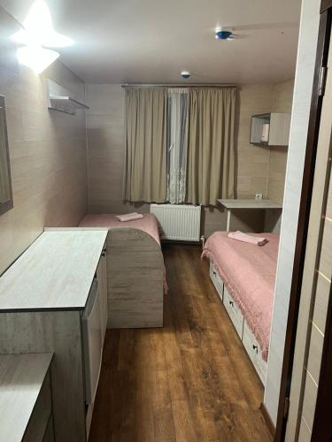 um pequeno quarto com 2 camas e uma secretária em NewHome em Chisinau