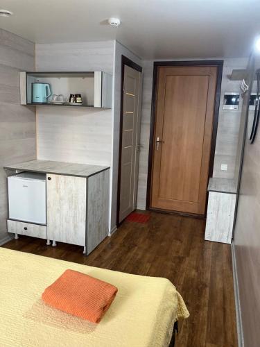 een slaapkamer met een bed, een keuken en een deur bij NewHome in Chişinău